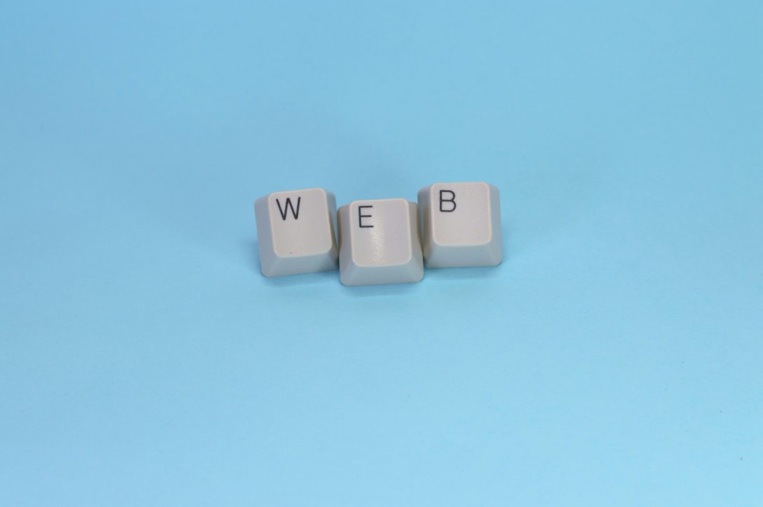 Keyboard keys spelling web on blue background representing WordPress permalink and URL structure