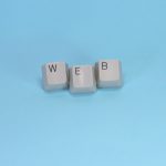 Keyboard keys spelling web on blue background representing WordPress permalink and URL structure