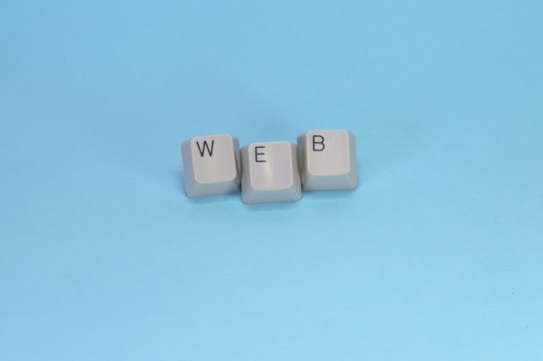 Keyboard keys spelling web on blue background representing WordPress permalink and URL structure