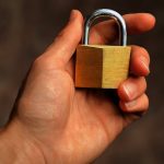Hand holding a secure padlock representing WordPress security audit checklist