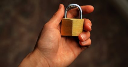 Hand holding a secure padlock representing WordPress security audit checklist